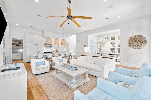 living area with a ceiling fan, recessed lighting, visible vents, and light wood finished floors