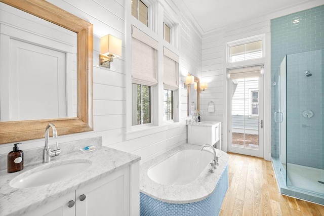 full bath featuring a sink, a wealth of natural light, a stall shower, and wood finished floors