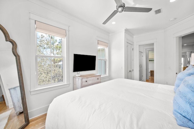 bedroom featuring visible vents, light wood-style flooring, recessed lighting, crown molding, and baseboards