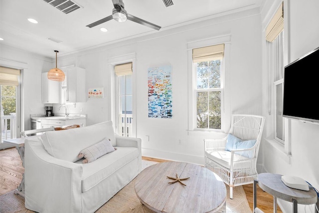 living area featuring light wood finished floors, visible vents, baseboards, recessed lighting, and a ceiling fan