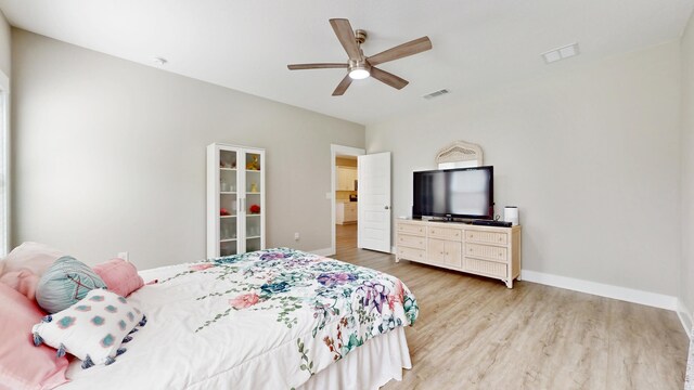 bedroom featuring baseboards, ceiling fan, visible vents, and light wood-style floors