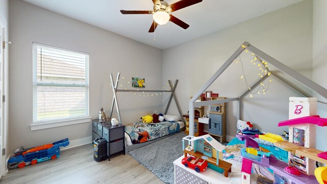 recreation room featuring a ceiling fan, baseboards, and wood finished floors