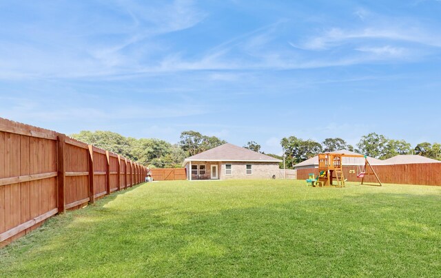 view of yard featuring a playground and a fenced backyard