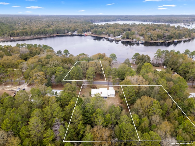 birds eye view of property with a water view and a wooded view