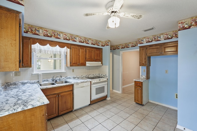 kitchen featuring white appliances, visible vents, light countertops, under cabinet range hood, and a sink