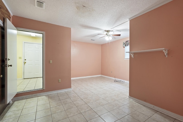 unfurnished room featuring ceiling fan, visible vents, a textured ceiling, and light tile patterned flooring