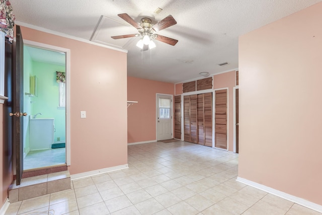 unfurnished room featuring light tile patterned floors, visible vents, a ceiling fan, a textured ceiling, and baseboards