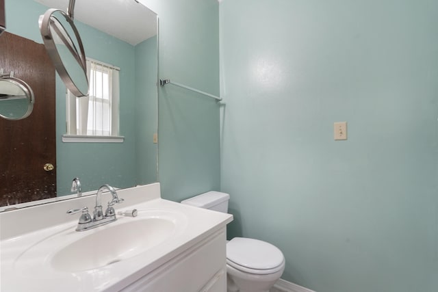 half bathroom with vanity and toilet