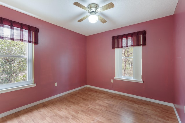 unfurnished room with ceiling fan, wood finished floors, and baseboards