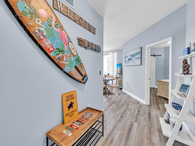 hallway with wood finished floors and baseboards