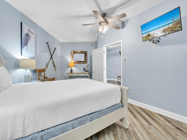 bedroom featuring a ceiling fan, baseboards, and wood finished floors