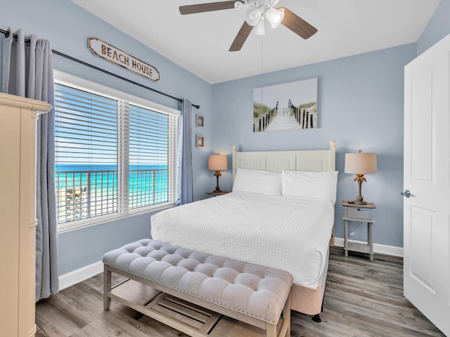 bedroom with a ceiling fan, baseboards, and wood finished floors