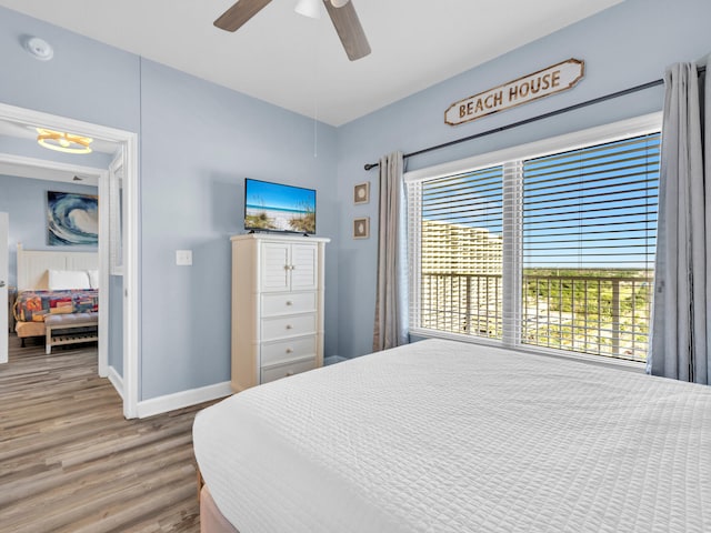 bedroom with ceiling fan, baseboards, and wood finished floors