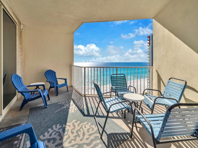 balcony featuring a water view and a view of the beach