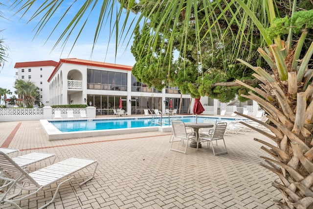 pool with a patio area and fence