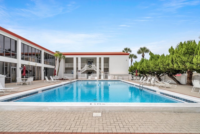 community pool featuring fence and a patio