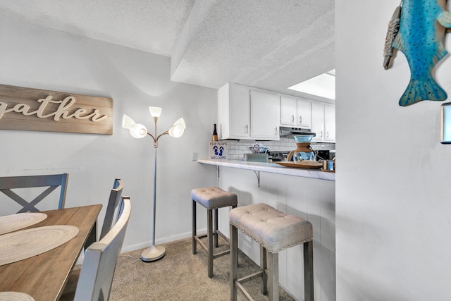 909 Santa Rosa Blvd Unit 537, Fort Walton Beach, FL 32548 - dining area with light colored carpet, a textured ceiling, and baseboards