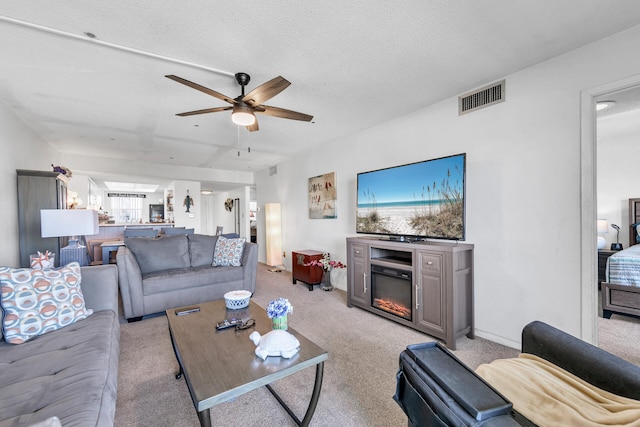 909 Santa Rosa Blvd Unit 537, Fort Walton Beach, FL 32548 - living area featuring visible vents, light carpet, a glass covered fireplace, and a ceiling fan