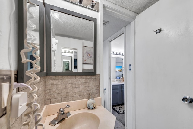 909 Santa Rosa Blvd Unit 537, Fort Walton Beach, FL 32548 - bathroom featuring vanity, tasteful backsplash, and a textured ceiling