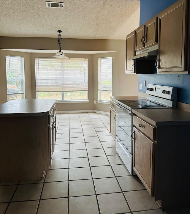 kitchen with light tile patterned flooring, a healthy amount of sunlight, under cabinet range hood, and stainless steel range with electric cooktop