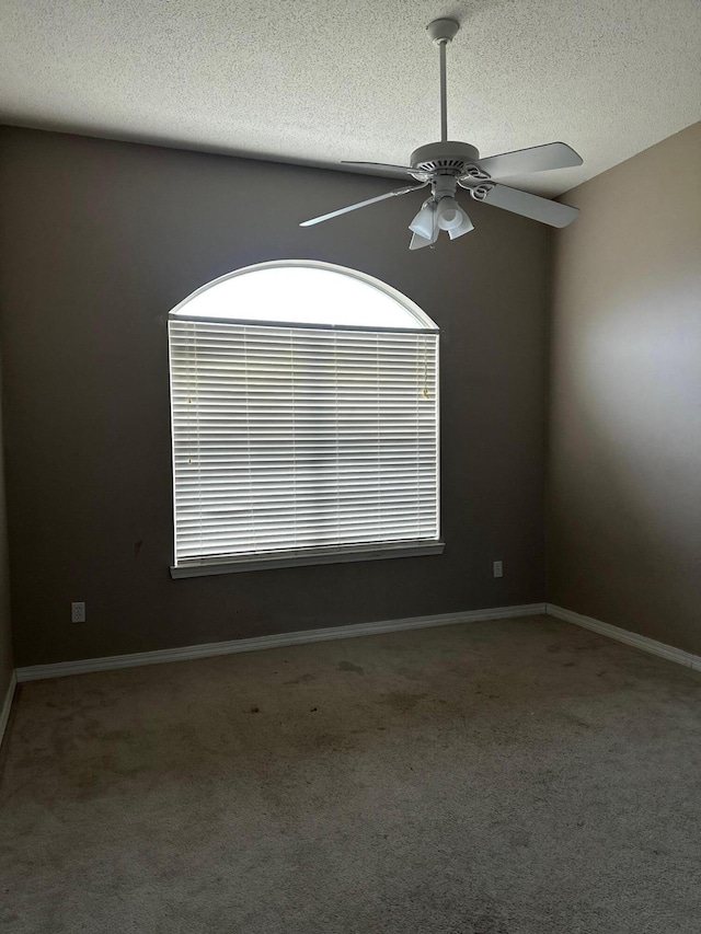 empty room featuring baseboards, carpet, a ceiling fan, and a textured ceiling