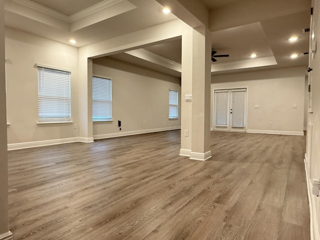 empty room featuring ceiling fan, crown molding, a tray ceiling, and wood finished floors