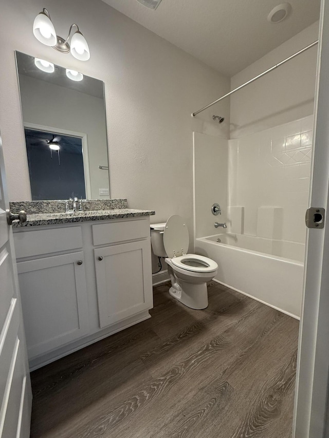 full bathroom with tub / shower combination, toilet, vanity, and wood finished floors