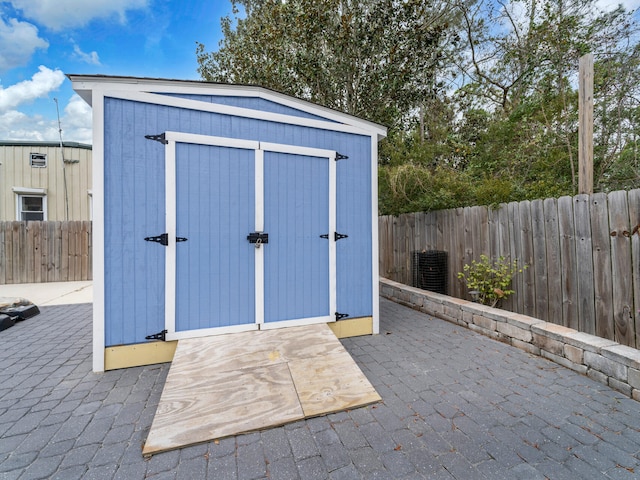 view of shed with central air condition unit and a fenced backyard