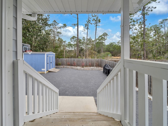 view of yard featuring an outbuilding, a patio, a shed, and fence