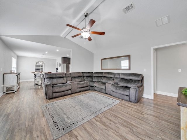 living area with vaulted ceiling with beams, wood finished floors, a ceiling fan, visible vents, and baseboards