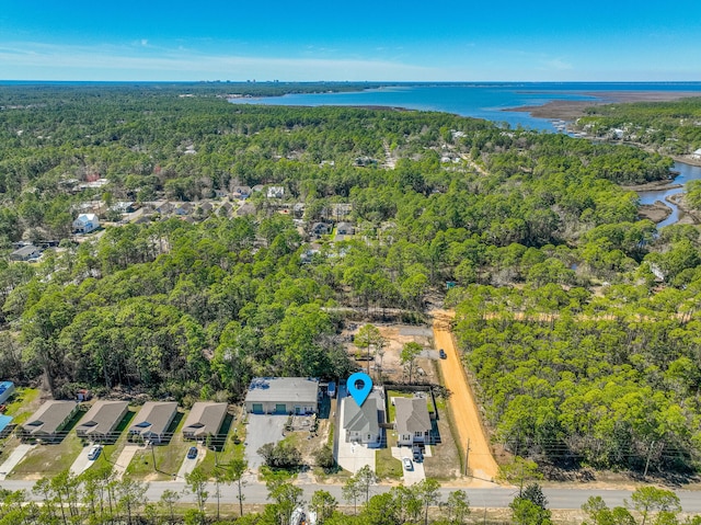 birds eye view of property with a water view and a wooded view