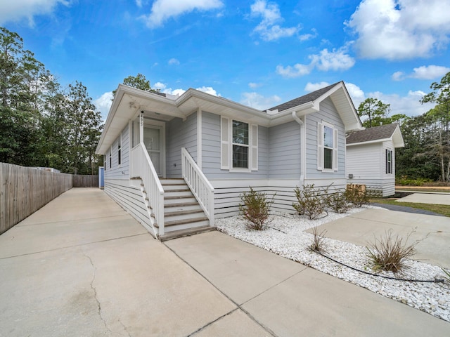 view of front of property with concrete driveway and fence