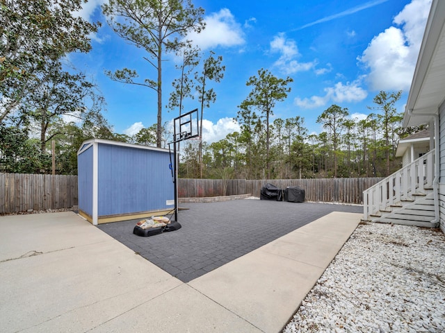 view of patio / terrace featuring an outbuilding, a fenced backyard, and a storage shed