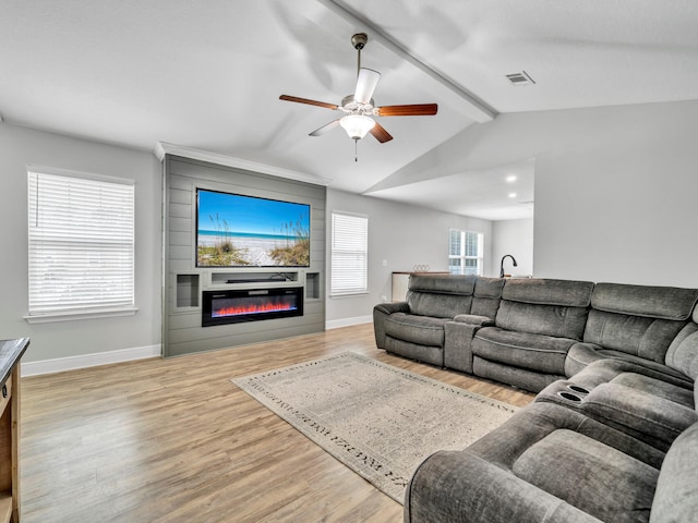 living room with vaulted ceiling with beams, a fireplace, wood finished floors, visible vents, and baseboards