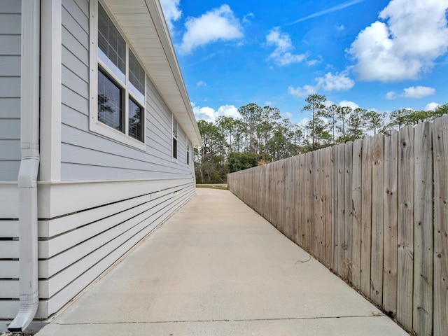 view of home's exterior with fence and a patio