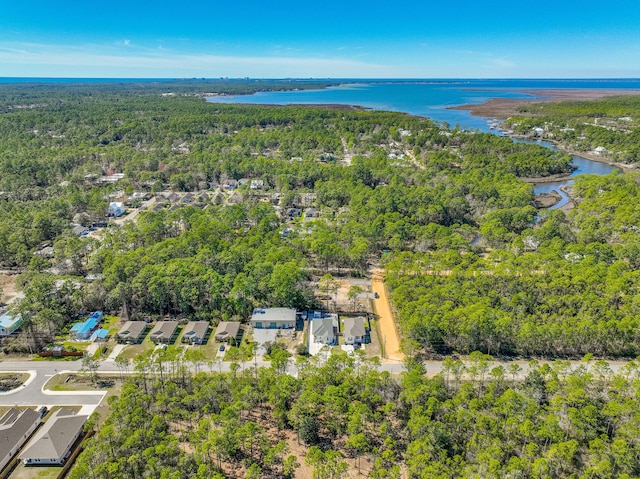 drone / aerial view with a water view and a forest view