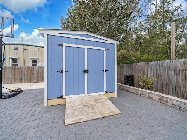 view of shed featuring cooling unit and a fenced backyard