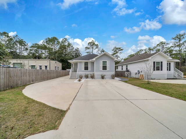 view of front facade featuring entry steps, fence, and a front lawn