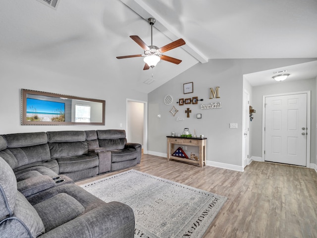 living room featuring vaulted ceiling with beams, baseboards, and light wood-style floors