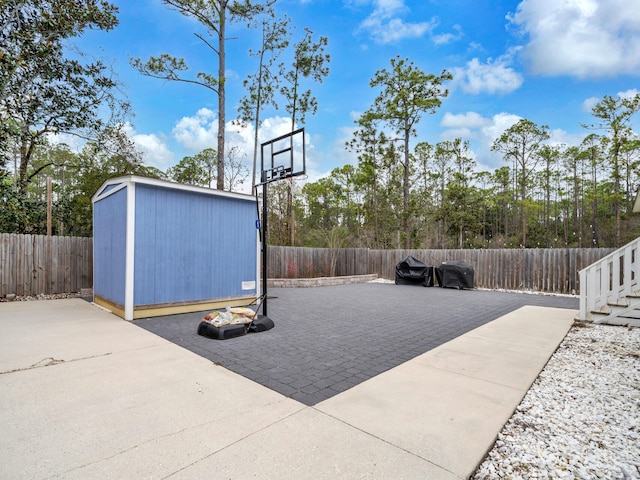 view of patio featuring an outbuilding, a fenced backyard, and a shed