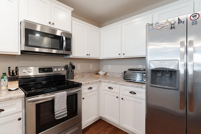 kitchen with dark wood finished floors, a toaster, white cabinetry, and stainless steel appliances