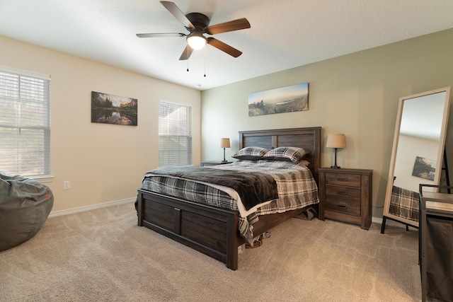 bedroom featuring ceiling fan, a textured ceiling, baseboards, and carpet