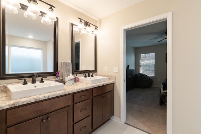 full bath with double vanity, ensuite bathroom, ceiling fan, and a sink