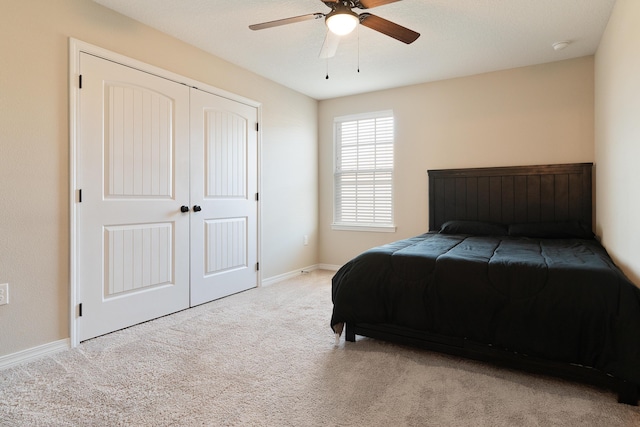 bedroom featuring a closet, baseboards, ceiling fan, and carpet flooring