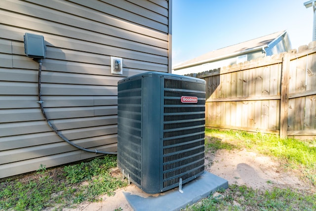 exterior details with central air condition unit and fence