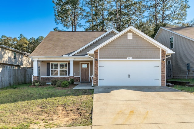 craftsman inspired home with fence, concrete driveway, a front yard, a garage, and stone siding