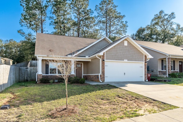 craftsman-style home with driveway, stone siding, fence, a front yard, and an attached garage