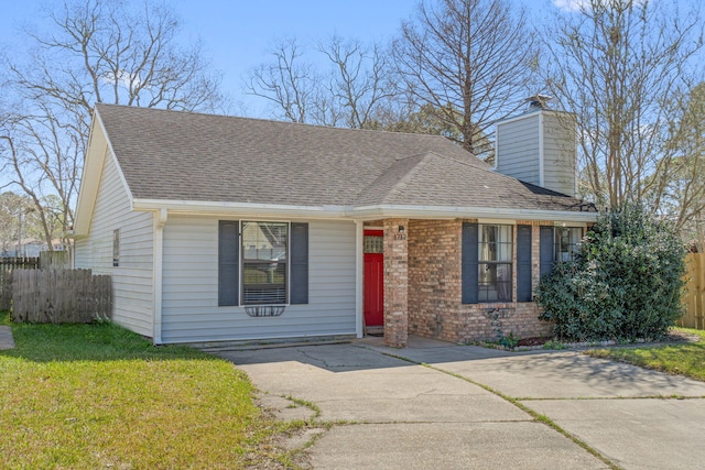 view of front of home featuring brick siding, a shingled roof, fence, and a front yard