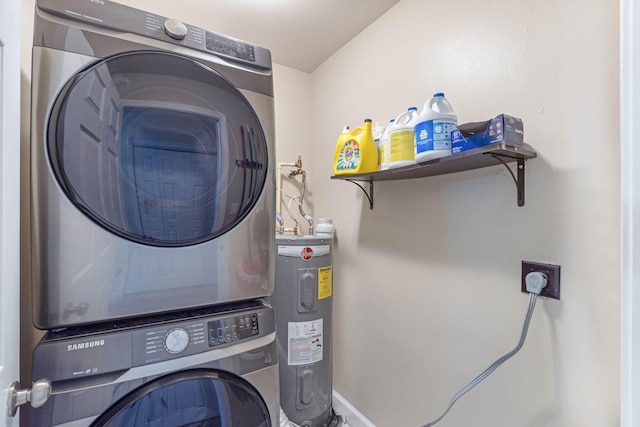 washroom with water heater, laundry area, stacked washer and clothes dryer, and baseboards