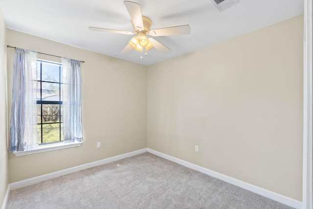 carpeted spare room with visible vents, ceiling fan, and baseboards